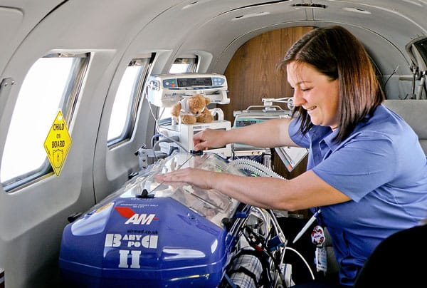 The BabyPod 2 infant transport device for transporting infants by plane used by a female nurse.